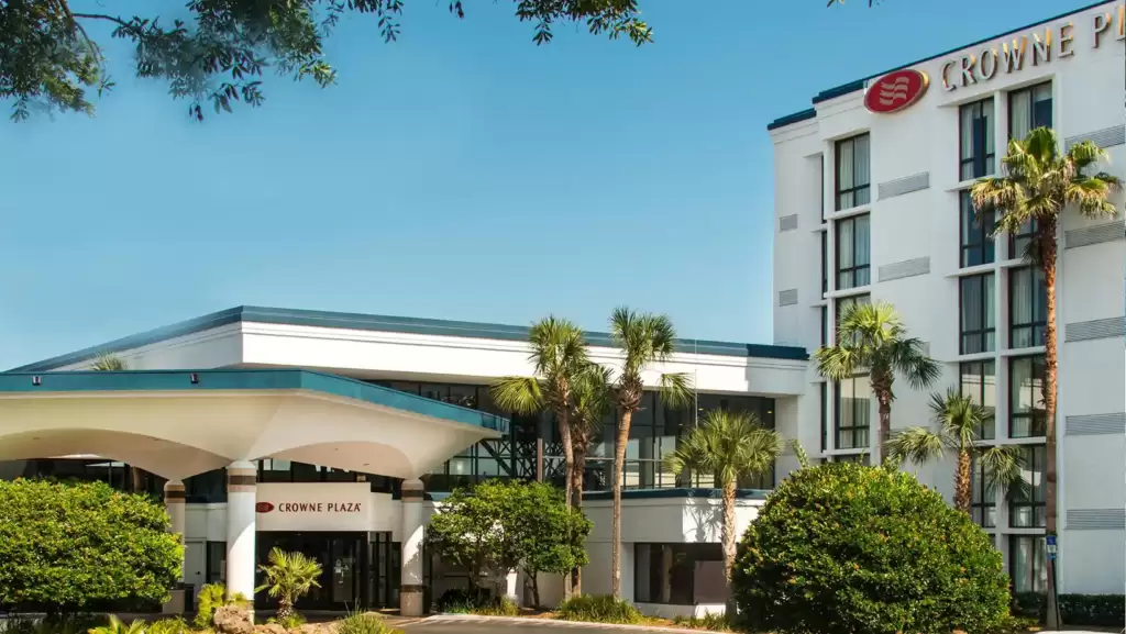 Crowne Plaza Jacksonville Airport hotel surrounded by beautiful green trees and under blue sky