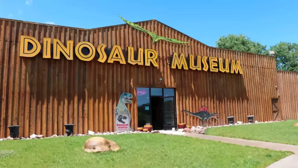 In a magnificent museum filled with awe-inspiring exhibits, visitors are captivated by the grandeur of life-sized dinosaurs, their colossal forms looming over the awe-struck crowd.