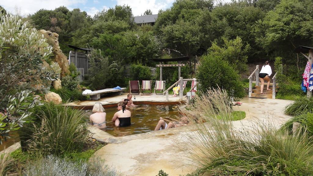 Peoples are taking bath in the hot spring, which is surrounded by trees