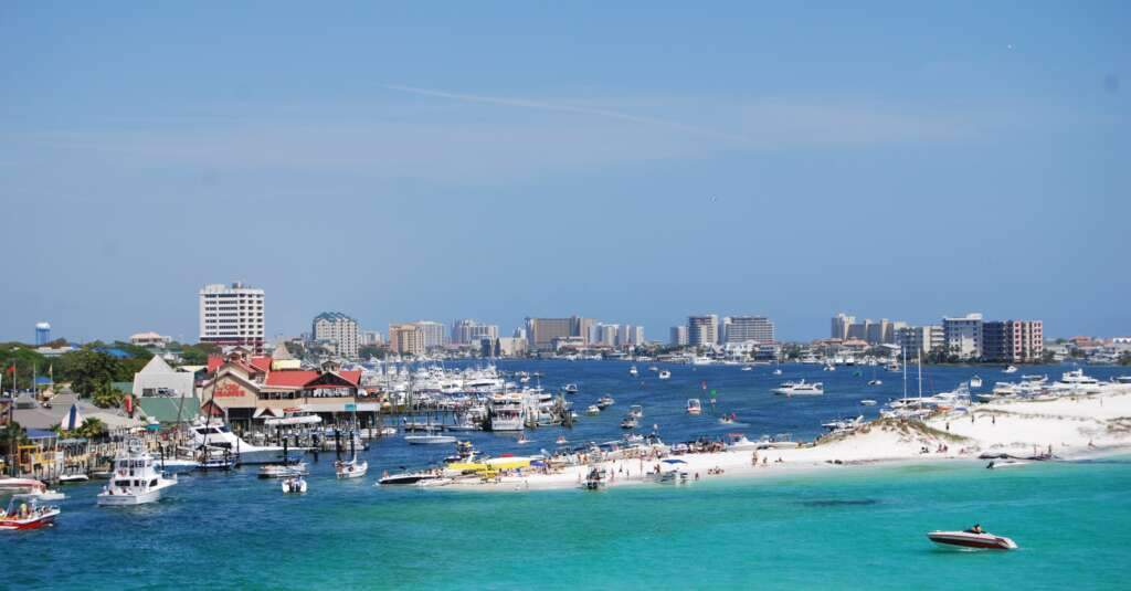 The drone view of Destin Florida, beach, river, buildings and crowd of people