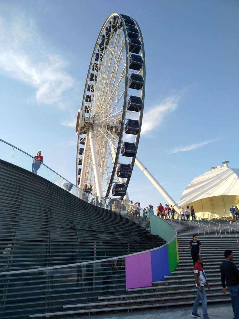 Peoples are enjoying around Centennial Wheel under the clean blue sky