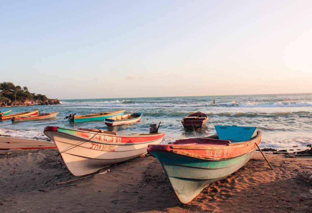 white and blue boat on beach during daytime looks beautiful. Enjoy during daytime is the best time to visit Belize