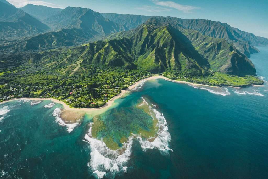We are exploring the best time to visit Hawaii. An aerial view of green and brown mountains and lake