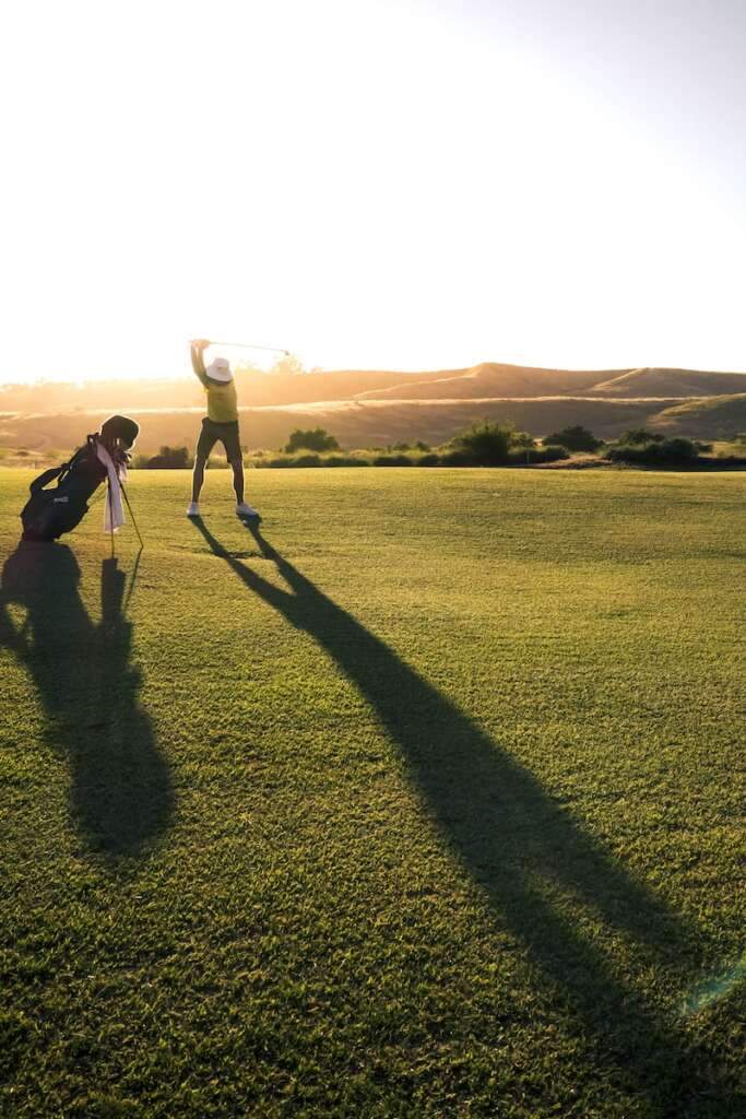 2 person Playing Golf on green grass field during daytime. Enjoying golf is one of the amazing things to do in Diani Beach