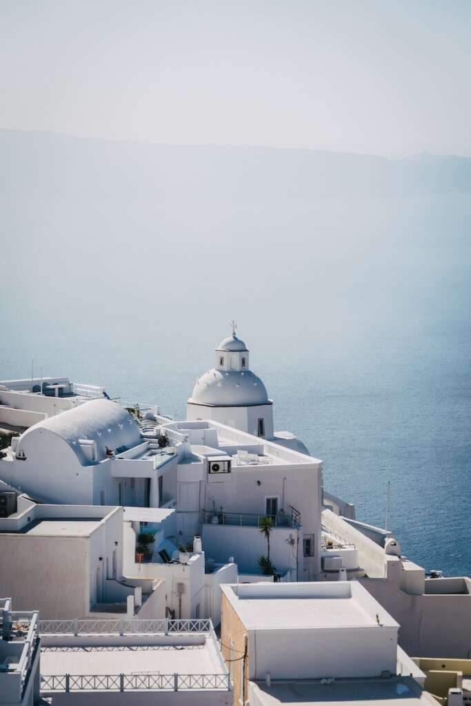 a white building with a white dome on top of Fira. If you are searching for where to stay in Santorini for nightlife. Then Fira is the best place to visit.