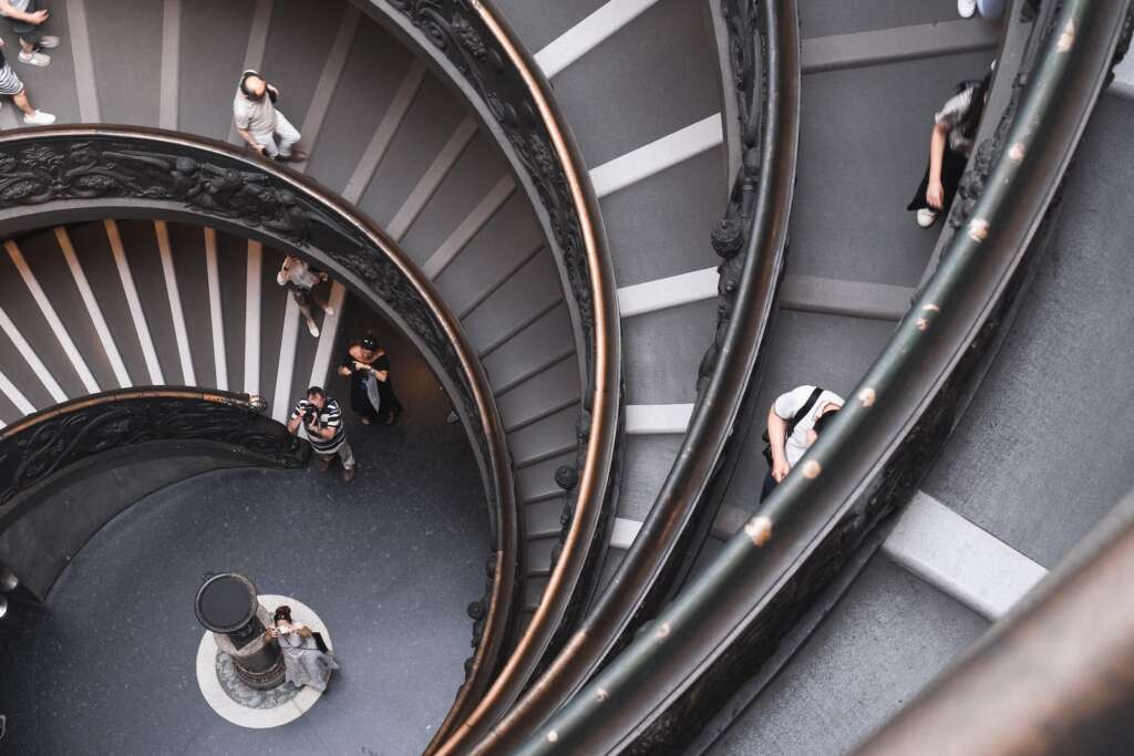 Renaissance Art.: here ae are explorig the best time to visit Italy. it is the top-view photography of people walking down on spiral stairs
