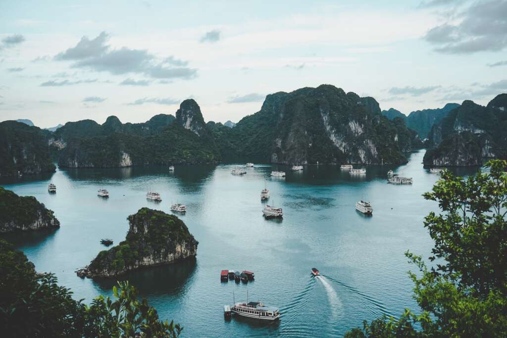 high-angle photography of boats on water near hill during daytime . It is the best time to visit Vietnam